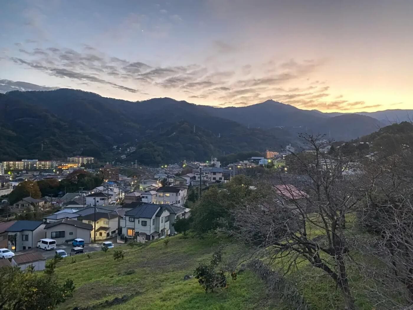 A quiet Japanese town nestled in mountains at dusk, representing "Not-Tokyo" areas where the Japan Market holds significant Untapped Value for strategic Investment.