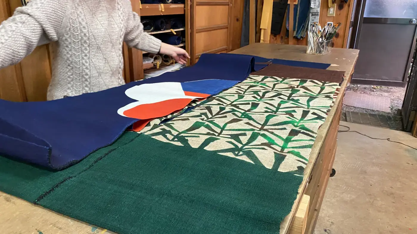 A Japanese artisan embodies the Artisan Mindset, displaying traditional textiles. This image highlights the meticulous craftsmanship that can be leveraged for Business Growth.