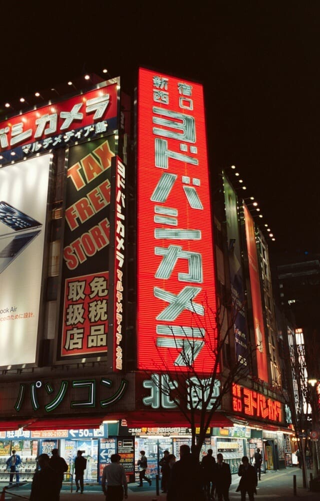 Vibrant neon signs illuminate a busy Tokyo street at night, showcasing advanced Japan technology and urban innovation amidst discussions on copyright law.