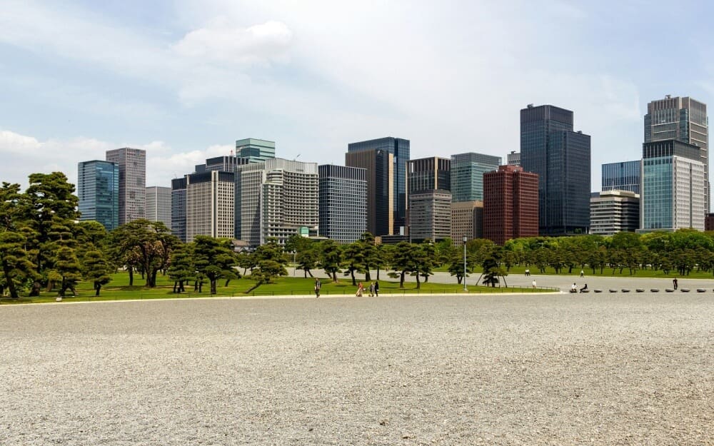 Modern Tokyo skyline contrasting with the Imperial Palace East Garden, representing Japan's economic landscape and future potential.