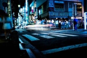 Tokyo night street scene with motion blur reflecting the economic Stagnation within Japan's Hollow Empire.