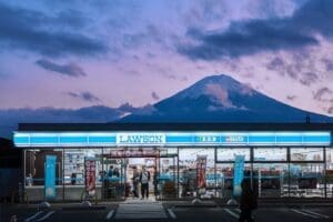 Lawson convenience store at dusk with Mount Fuji in the background, a common sight for Japan travel often affected by tourist behavior issues.