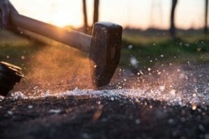 A powerful sledgehammer striking the ground, creating sparks, symbolizing the brute-force, destructive approach many Japan businesses take toward digital strategy due to a lack of digital literacy in Japan.